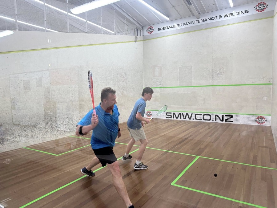 Members playing on a glass backed court